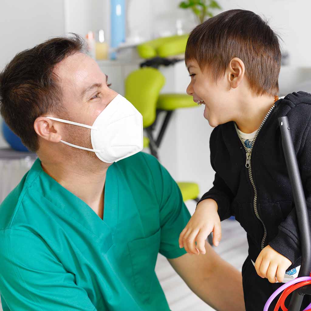 boy with intellectual disability smiles to support worker
